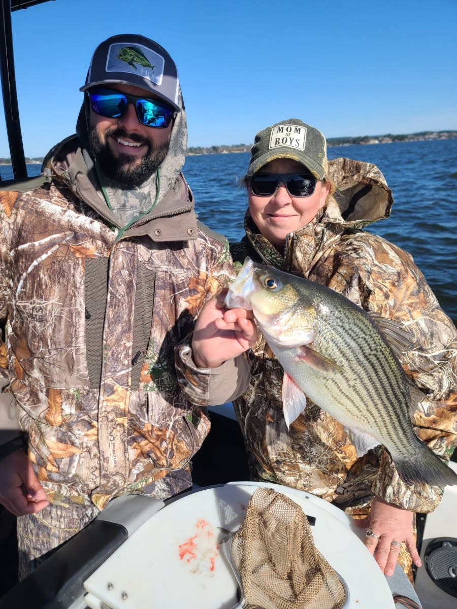 Collin Edwards Professional Guide of Lake Conroe Fishing Adventures Holds Hybrid Striped Bass with Customer