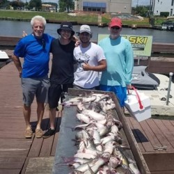 Lake Conroe Fishing Adventures Customers Stand Next to Fillet Table Full of Catfish on Lake Conroe
