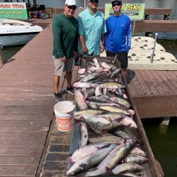 Lake Conroe Fishing Adventures Customers Stand Next to Fillet Table Full of Catfish on Lake Conroe