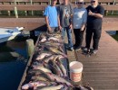 Lake Conroe Fishing Adventures Customers Stand Next to Fillet Table Full of Catfish on Lake Conroe