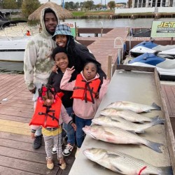 Lake Conroe Fishing Adventures Customers Stand Next to Fillet Table Full of Hybrid Striped Bass on Lake Conroe