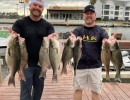 Lake Conroe Fishing Adventures Customers Stand Next to Fillet Table Holding Hybrid Striped Bass on Lake Conroe