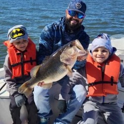 Collin Edwards Licensed Professional Fishing Guide on Lake Conroe Holds Trophy Large Mouth Bass with Young Customers