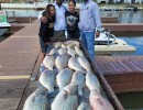 Lake Conroe Fishing Adventures Customers Stand Next to Fillet Table Full of Hybrid Striped Bass on Lake Conroe