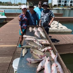 Lake Conroe Fishing Adventures Customers Stand Next to Fillet Table Full of Catfish on Lake Conroe