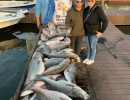 Lake Conroe Fishing Adventures Customers Stand Next to Fillet Table Full of Hybrid Striped Bass on Lake Conroe