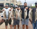 Lake Conroe Fishing Adventures Customers Stand Next to Fillet Table Holding Hybrid Striped Bass on Lake Conroe